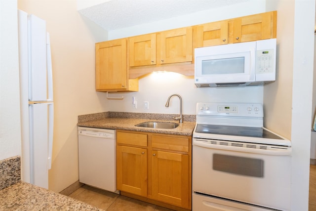 kitchen featuring a textured ceiling, light tile patterned flooring, white appliances, and sink