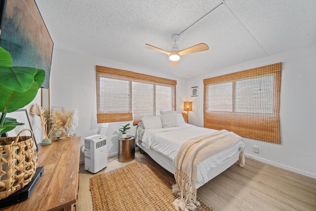 2495 S Kihei Rd Unit 175, Kihei, HI 96753 - bedroom featuring a textured ceiling, baseboards, a ceiling fan, and wood finished floors
