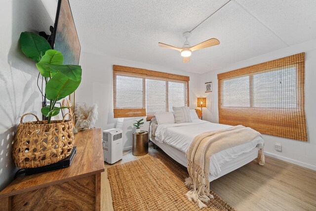 2495 S Kihei Rd Unit 175, Kihei, HI 96753 - bedroom featuring a textured ceiling, a ceiling fan, baseboards, and wood finished floors