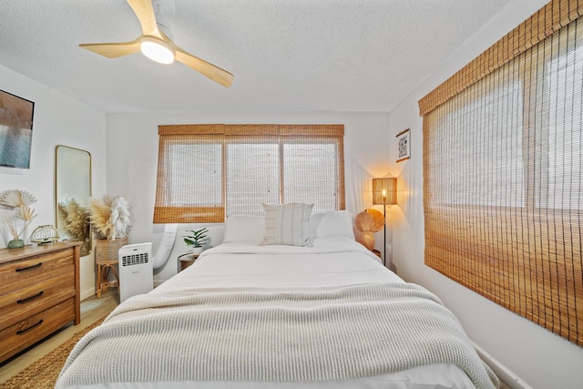 2495 S Kihei Rd Unit 175, Kihei, HI 96753 - bedroom featuring a textured ceiling, a ceiling fan, and light wood-style floors