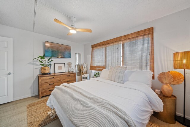 2495 S Kihei Rd Unit 175, Kihei, HI 96753 - bedroom featuring light wood-type flooring, baseboards, a ceiling fan, and a textured ceiling