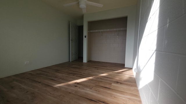 unfurnished bedroom with a closet, hardwood / wood-style floors, and ceiling fan