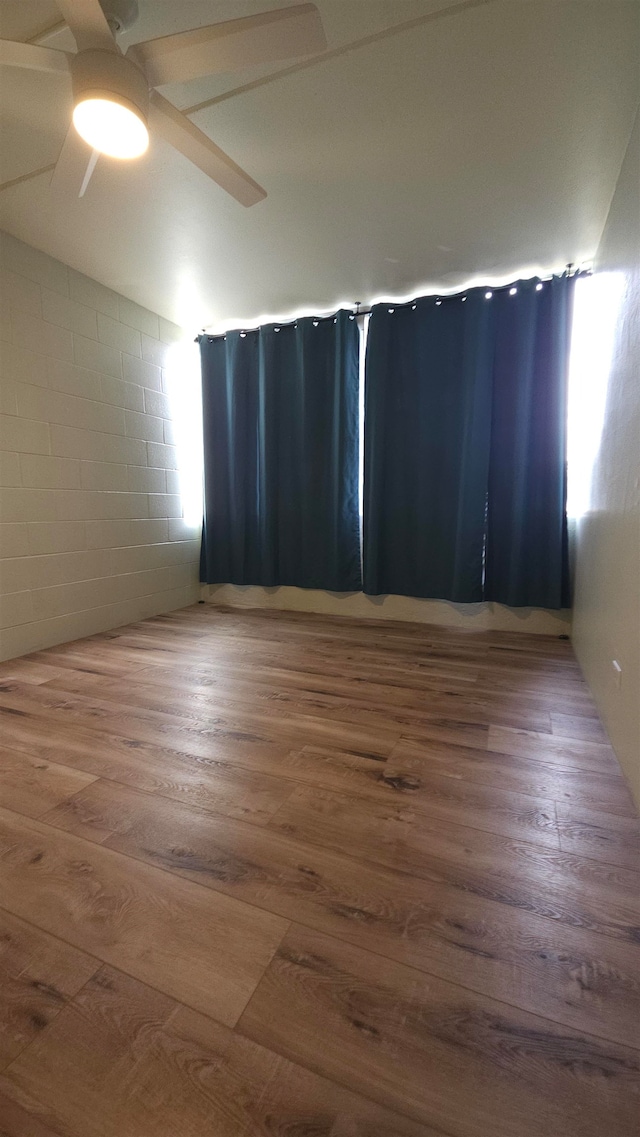 unfurnished room with wood-type flooring, vaulted ceiling, and ceiling fan