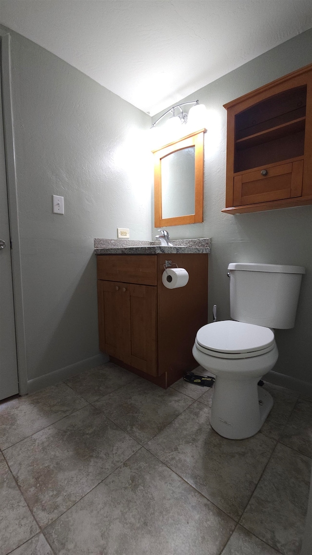 bathroom with vanity, toilet, and tile patterned floors