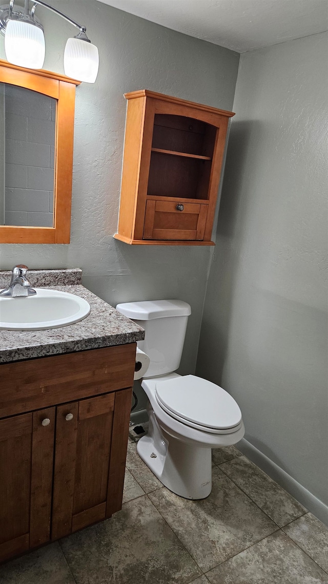 bathroom with vanity, tile patterned flooring, and toilet