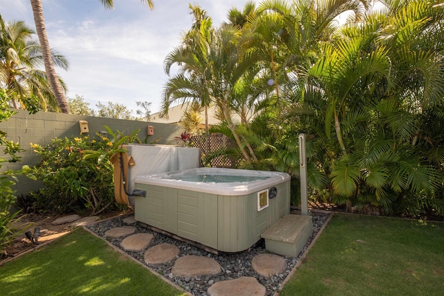 view of yard with central AC, a hot tub, and fence