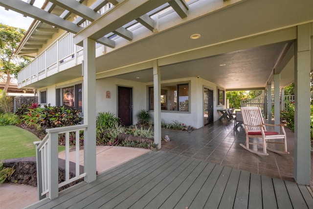 wooden deck featuring a porch, a pergola, and fence