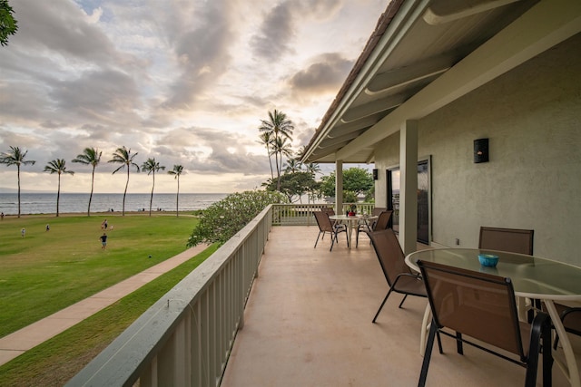 balcony with a water view and outdoor dining area
