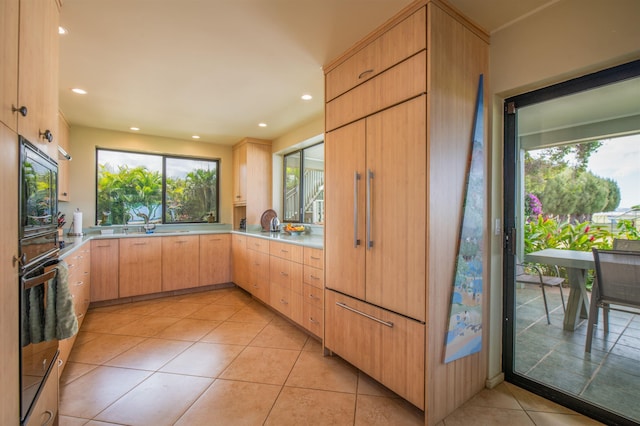 kitchen with recessed lighting, light countertops, light tile patterned floors, and light brown cabinets