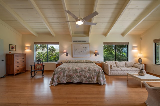 bedroom with wood finished floors, a wall unit AC, and multiple windows