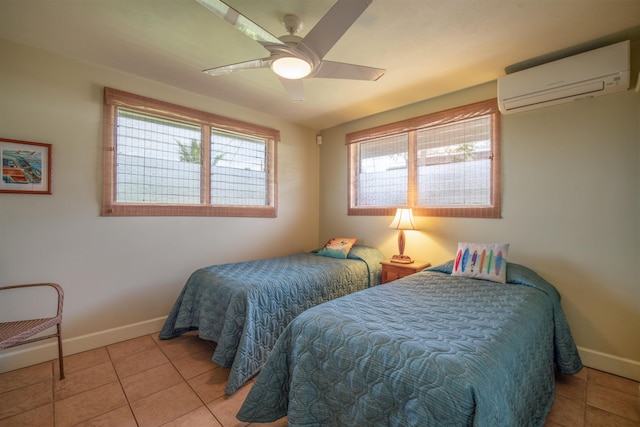 bedroom with light tile patterned floors, baseboards, ceiling fan, and a wall unit AC
