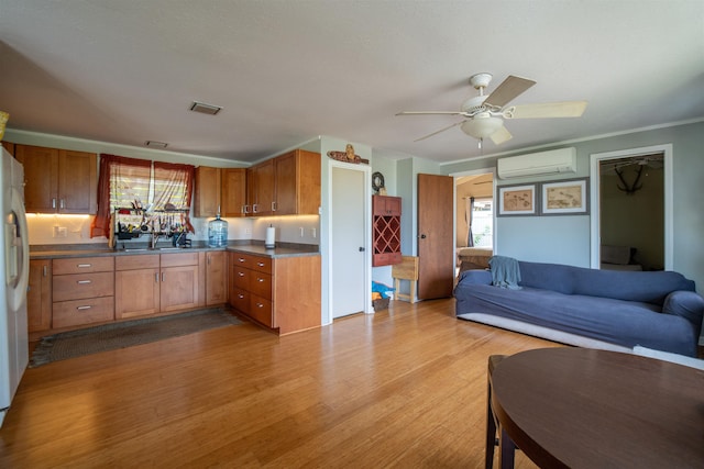kitchen with a sink, plenty of natural light, a wall mounted AC, and open floor plan