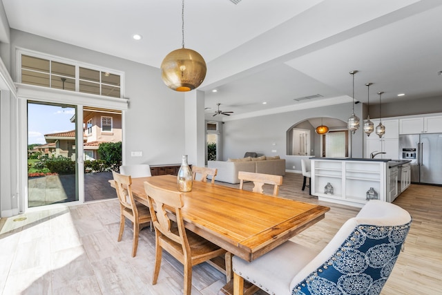 dining space with crown molding, ceiling fan, and light hardwood / wood-style flooring