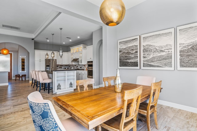 dining space featuring light hardwood / wood-style flooring and ornamental molding