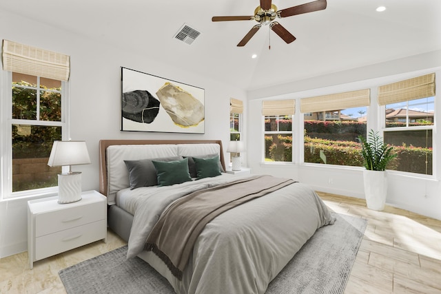 bedroom featuring ceiling fan, vaulted ceiling, and multiple windows