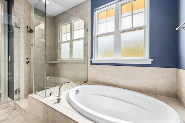 bathroom featuring a healthy amount of sunlight and separate shower and tub