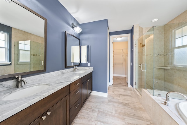 bathroom with a healthy amount of sunlight, vanity, and separate shower and tub