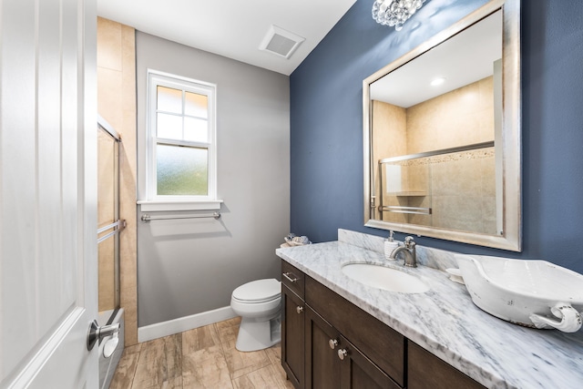 bathroom with toilet, wood-type flooring, vanity, and a shower with shower door