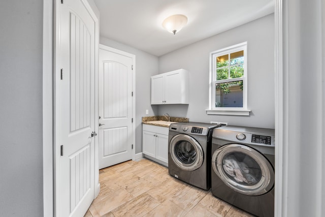 washroom featuring cabinets, sink, and washing machine and clothes dryer