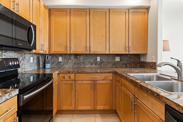 kitchen featuring dark stone counters, sink, light tile patterned floors, tasteful backsplash, and stainless steel appliances