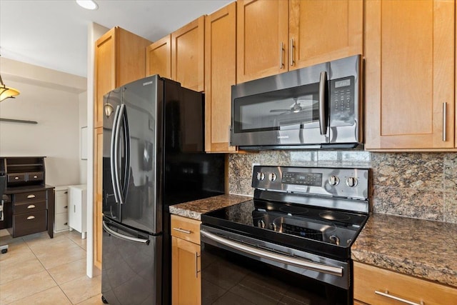 kitchen with decorative backsplash, light tile patterned flooring, stainless steel appliances, and dark stone counters