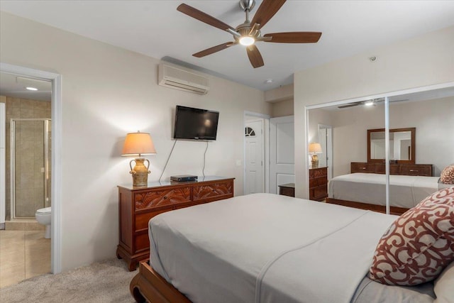 bedroom with connected bathroom, ceiling fan, a wall mounted AC, a closet, and light tile patterned floors