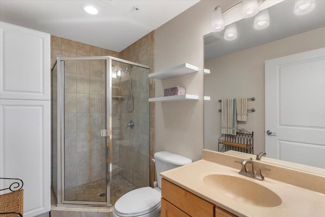 bathroom with vanity, a shower with shower door, and toilet