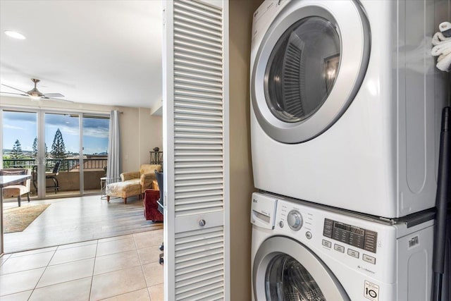 washroom featuring ceiling fan, stacked washer and dryer, and light tile patterned flooring