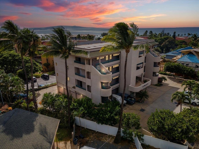 aerial view at dusk featuring a water view