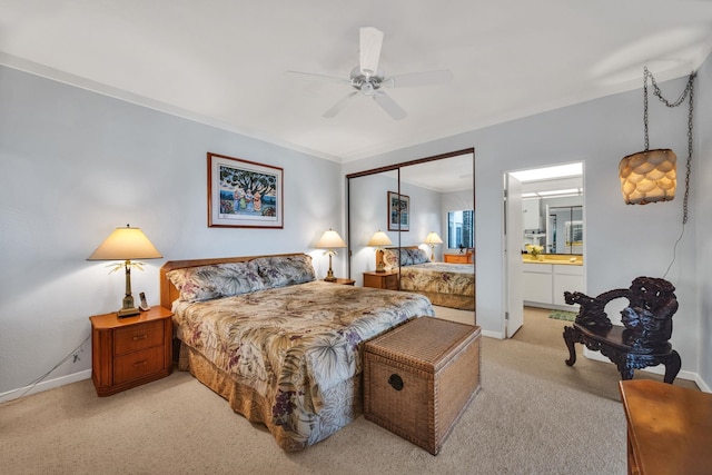 bedroom with baseboards, light carpet, ensuite bath, and ceiling fan