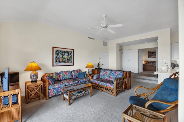 living room featuring visible vents, ornamental molding, ceiling fan, and carpet floors