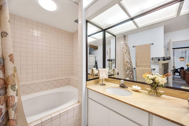 bathroom featuring tiled shower / bath combo and vanity