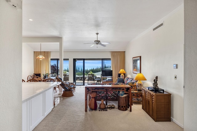 carpeted living room with visible vents and ceiling fan with notable chandelier