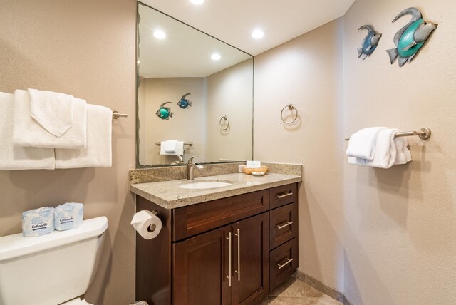 bathroom featuring toilet, vanity, and tile patterned flooring