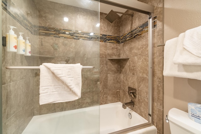 bathroom featuring shower / bath combination with glass door and toilet