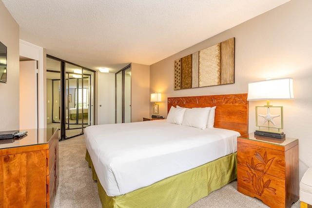 bedroom featuring light colored carpet and a textured ceiling