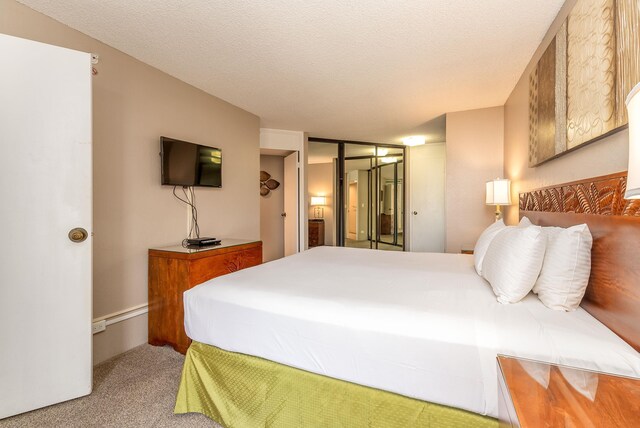 bedroom with light colored carpet and a textured ceiling