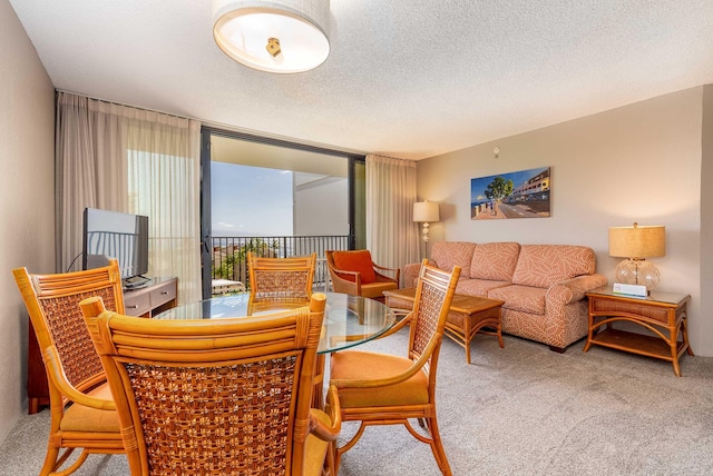 dining area with a wall of windows, carpet, and a textured ceiling