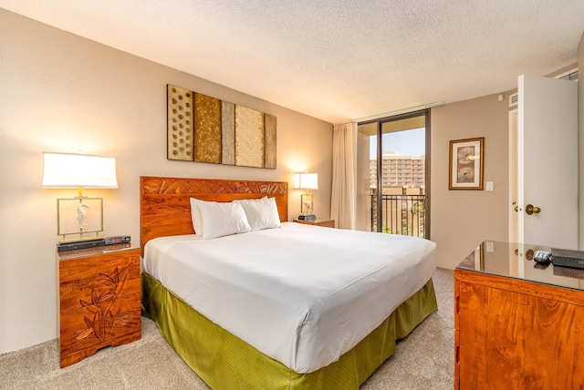 bedroom featuring light colored carpet, a textured ceiling, and access to exterior