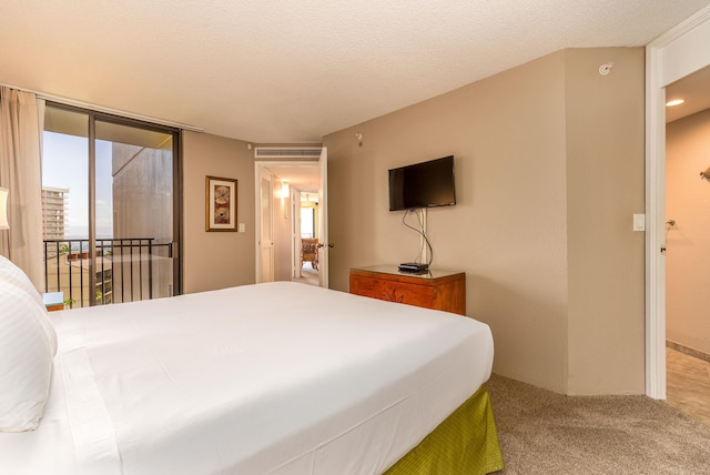 bedroom featuring a textured ceiling, access to outside, and carpet flooring