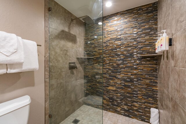 bathroom featuring toilet and tiled shower