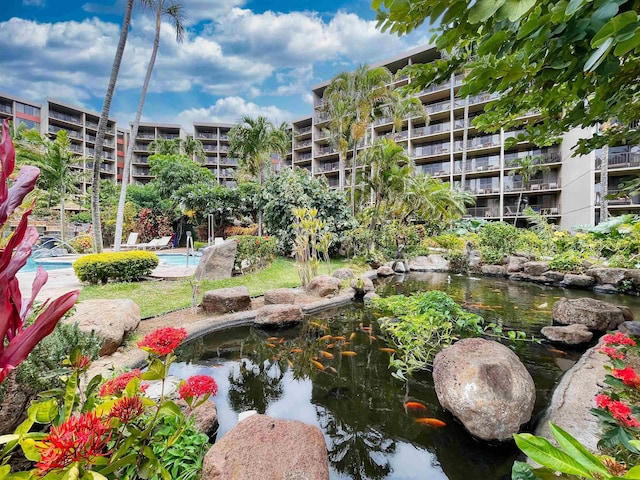 surrounding community with a swimming pool and a garden pond