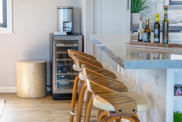 stairway with wood finished floors, a dry bar, and beverage cooler