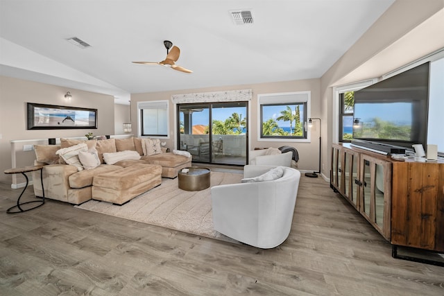 living room featuring vaulted ceiling, a healthy amount of sunlight, and visible vents