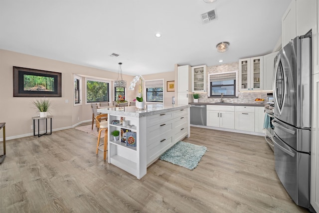 kitchen with visible vents, open shelves, decorative backsplash, appliances with stainless steel finishes, and a sink