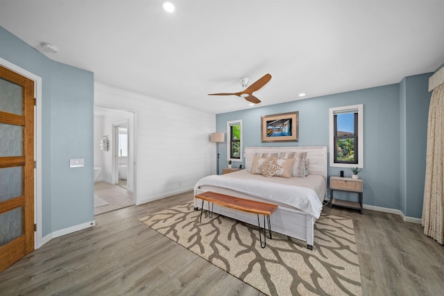 bedroom with multiple windows, baseboards, and wood finished floors