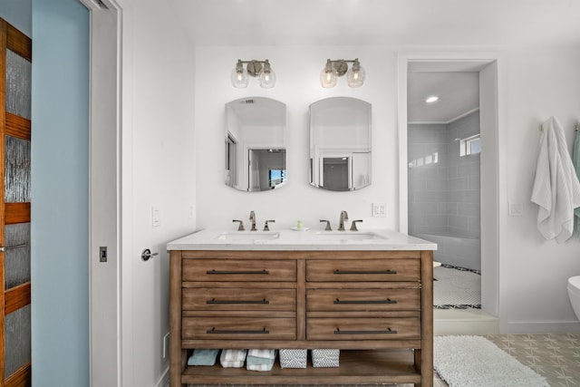 full bath featuring a shower stall, double vanity, baseboards, and a sink