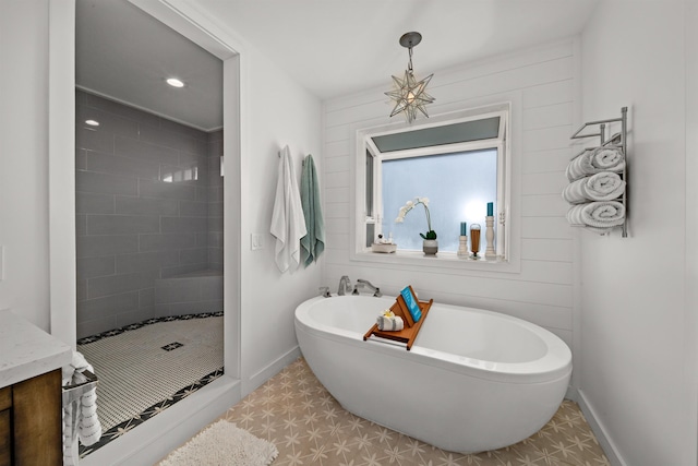 bathroom with recessed lighting, baseboards, a soaking tub, and a shower stall