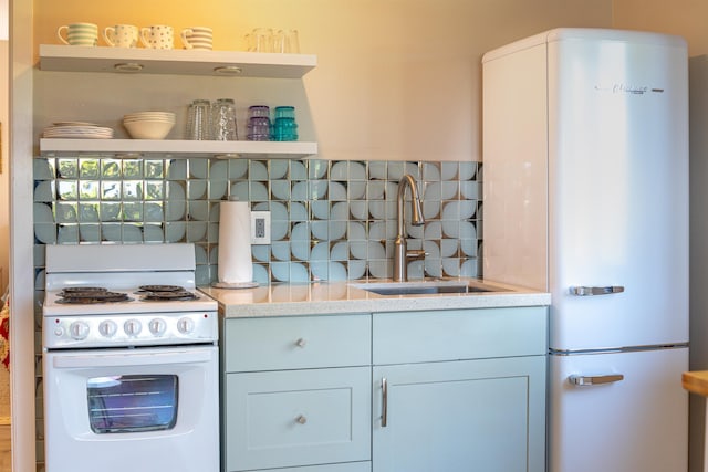 kitchen featuring white appliances, open shelves, backsplash, and a sink