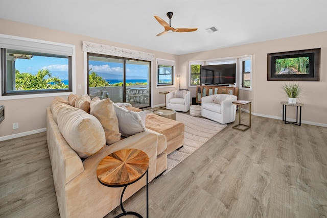 living room with visible vents, baseboards, wood finished floors, and a ceiling fan